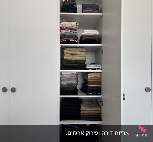 ארון בגדים מסודר עם בגדים מקופלים